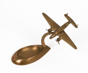 Trench Art: Lockheed Hudson mounted on ashtray with RAAF badge, c. 1940s, solid brass, 13cm high and 15.5cm wingtip to wingtip.