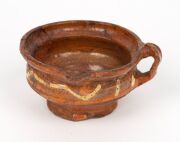 An antique Dutch pottery cup with trailing slip glaze; together with a similar undecorated example, 17th century, (2 items) the larger 6.5cm high, 12.5cm wide - 8