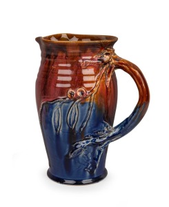 ALLAN JAMES rare blue and pink pottery jug with brown highlights, decorated with applied gumnuts, leaves and branch handle, incised "A. James, 1933", 23cm high. Illustrated in "Australian Art Pottery 1900-1950" plate 57.