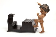 A vintage&nbsp;bakelite kookaburra cigarette dispenser; together with a Brownie Downing porcelain figural plaque, 20th century, (2 items), the cigarette dispenser 19cm wide