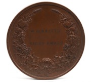 MEDAL: 1879 SYDNEY INTERNATIONAL EXHIBITION large bronze medal by Wyon (76mm), engraved to "W. BENNETTS, FIRST PRIZE". ​​​​​​​This is a large bronze prize medal featuring a view of the Sydney Garden Palace Exhibition Building with a figure of New South Wa - 2