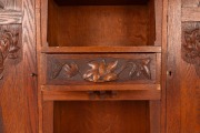 An Australian Arts & Crafts bookcase with knee hole desk compartment, manufactured in American oak, carved with Illawarra flame tree motif, early 20th century, with original ink stamp to the reverse of drawer "MISS GETHERS, WOOD CARVING STUDIO, SYDNEY", 1 - 2