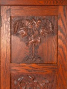 An Australian Arts & Crafts bookcase with knee hole desk compartment, manufactured in American oak, carved with Illawarra flame tree motif, early 20th century, with original ink stamp to the reverse of drawer "MISS GETHERS, WOOD CARVING STUDIO, SYDNEY", 1 - 3