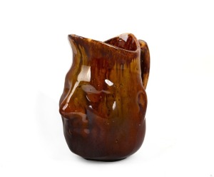 An antique Australian pottery face jug with mottled brown glaze, 14cm high