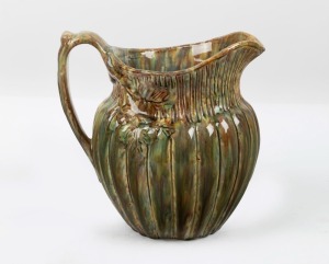 BOSLEY (attributed) unusual mottled green glazed pottery jug with ribbed and incised decoration, branch handle and leaves, 18.5cm high