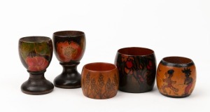 MADGE FREEMAN hand-painted huon pine miniature vase, signed "Madge Freeman, 1924"; together with a pair of huon pine pokerwork floral egg cups and two pokerwork napkin rings, circa 1920s, (5 items), the largest 7cm high