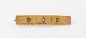 An antique 18ct yellow gold brooch, set with a central diamond flanked by two green sapphires, 19th century, stamped "18ct", 5.7cm wide, 9.7 grams
