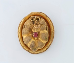 An antique Australian 18ct yellow gold mourning brooch with leaf decorated lift front, set with red stone, circa 1855, ​​​​​​​4cm high, 13.8 grams total including mourning windows