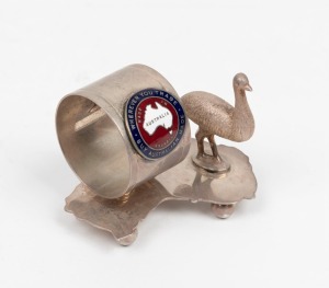 An Australian silver plated napkin ring with emu decoration on map of Australia, adorned with enamel plaque "Whenever You Trade, Buy Australian Made", 6cm high