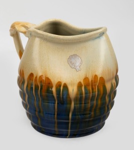 REMUED blue and cream glazed pottery jug with orange highlights, branch handle and ribbed decoration, incised "Remued", with original foil label, 15cm high