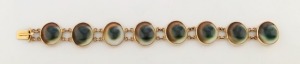 An 18ct gold bracelet set with eight operculum shells, South Australia origin circa 1870, stamped "18c",  17cm long