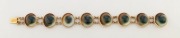 An 18ct gold bracelet set with eight operculum shells, South Australia origin circa 1870, stamped "18c",&nbsp; 17cm long
