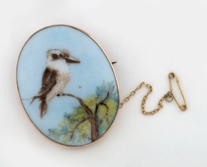 An antique Australian 9ct rose gold mounted oval porcelain brooch, hand-painted with kookaburra and wattle, early 20th century, stamped "9ct", 5cm high overall