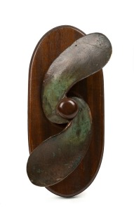 A vintage brass boat propeller mounted on timber board for hanging, 36cm high overall