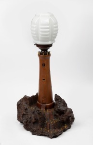 A vintage Australian folk art lighthouse lamp with mulga wood base, bakelite fittings and milk glass shade, mid 20th century, 63cm high