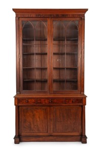An antique Colonial Australian cedar bookcase with Gothic arched doors, three drawers and full turned columns, New South Wales origin, mid 19th century. Note: This originally was a built-in bookcase, sides have been altered. 259cm high, 146cm wide, 47cm deep
