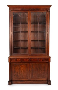 An antique Colonial Australian cedar bookcase with Gothic arched doors, three drawers and full turned columns, New South Wales origin, mid 19th century. Note: This originally was a built-in bookcase, sides have been altered. 259cm high, 146cm wide, 47cm d