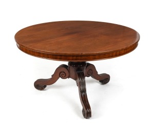 An antique Australian cedar tilt-top supper table with two piece book matched well figured top, cross banded edge and skirt supported on a turned pedestal with lotus carved collar and impressive scroll and lambs tongue cabriole legs with recessed brass ca