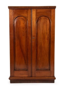 An antique Australian cedar two door stationery cabinet, full length blind doors fitted with arched cedar panels, circa 1870, 135cm high, 85cm wide, 30cm deep