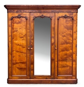 An antique Australian huon pine three door wardrobe with central mirrored door and carved decoration, 19th century. Note: Fine select cuts of  birdseye huon pine have been used in the construction of this piece shoring lovely colour and patination. 211cm 