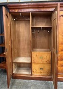 An antique Australian huon pine three door wardrobe with central mirrored door and carved decoration, 19th century. Note: Fine select cuts of&nbsp; birdseye huon pine have been used in the construction of this piece shoring lovely&nbsp;colour and patination. 211cm - 2
