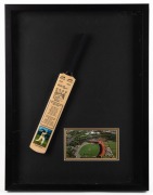 A Don Bradman, original pen signature on colour postcard of the Adelaide Cricket Ground, mounted together with a miniature Bradman commemorative bat; framed and glazed. Overall 55.5 x 42.5cm.