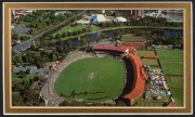 A Don Bradman, original pen signature on colour postcard of the Adelaide Cricket Ground, mounted together with a miniature Bradman commemorative bat; framed and glazed. Overall 55.5 x 42.5cm. - 2