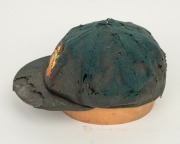 BILL JOHNSTON'S AUSTRALIAN 1947-48 BAGGY GREEN TEST TEAM CAP, green wool with embroidered Australian cost-of-arms and the dates "1947-48"embroidered to the front panel; "Farmers Sydney" label to the inside crown. Poor condition. Bill Johnston played in 4 - 5