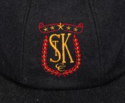 SHANE WARNE'S ST. KILDA CAP, black, with the embroidered "ST K CC" logo embroidered to the front panel. Signed by Warne to the back of the panel. Very good condition. Warne had joined the St. Kilda Cricket Club for the 1985-86 season when he was 16 years - 2