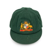 GRAEME WOOD'S AUSTRALIAN TEST TEAM BAGGY GREEN from the 1985 Ashes Tour of England, with the Australian coat-of-arms embroidered to the front panel; made by Albion, with their original label which also bears Wood's original signature in ink. Fine conditio