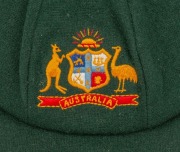 GRAEME WOOD'S AUSTRALIAN TEST TEAM BAGGY GREEN from the 1985 Ashes Tour of England, with the Australian coat-of-arms embroidered to the front panel; made by Albion, with their original label which also bears Wood's original signature in ink. Fine conditio - 2