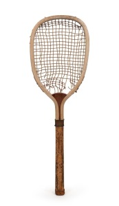 A Victorian era square-shaped tennis racquet, circa 1880s, made by S.W. TRIMMINGS with their company name stamped into the convex wedge; full length cork&nbsp;covered handle; gut stringing; brass and leather bands and butt cap. Length: 68cm.