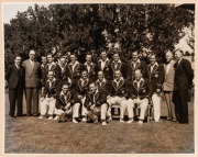 A large format (29.5 x 37.5cm) press photograph, signed verso by Sam Loxton, showing ten members of the 1948 Australian team during a visit to a private garden - admiring the goldfish; also, a team-issued photograph of the 1956 Australians in England, wit