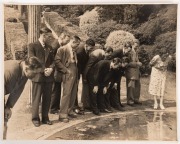 A large format (29.5 x 37.5cm) press photograph, signed verso by Sam Loxton, showing ten members of the 1948 Australian team during a visit to a private garden - admiring the goldfish; also, a team-issued photograph of the 1956 Australians in England, wit - 3
