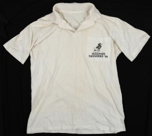 ex NATHAN BUCKLEY COLLECTION: Port Adelaide Premiers polo, 1992. White polo shirt with magpie caricature on breast pocket and the words ‘Magpies Premiers ‘92’