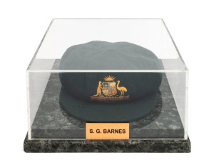 THE 1948 AUSTRALIAN TEST TEAM BAGGY GREEN CAP WORN BY SID BARNES: Green wool with embroidered Coat of Arms and 1948 to the front panel; Farmer's, Sydney label to the internal peak with "S. G. Barnes" added in manuscript. Overall in very good condition with a couple of tiny pinholes evident mentioned for accuracy. Accompanied by letter of authenticity dated July, 1992. Housed in custom made perspex case with marble base. 15cm high, 28cm wide, 32cm deep.