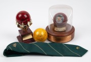 An Australian cricket tie, circa 1985; together with a Don Bradman presentation cricket ball, limited edition 501/974, a signed yellow cricket and a signed kookaburra cricket ball on stand, (4 items)