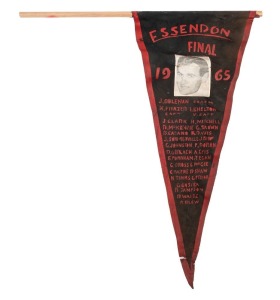 "ESSENDON FINAL 1965" supporters' pennant depicting Ken Frazer. 46cm. Essendon defeated St.Kilda in the Grand Final. The match, attended by 104,846 spectators, was won by Essendon by a margin of 35 points, marking that club's 12th premiership victory. The Bombers set up their win in the third quarter, scoring five goals to just one by the Saints. Ted Fordham kicked seven goals for Essendon.