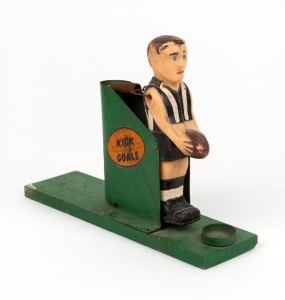 A vintage VFL goal-kicking toy, with the player in Collingwood stripes; timber, metal and plastic with a sticker to each side "KICK GOALS" and "HAVE FUN". 22.5cm long, 8cm tall.