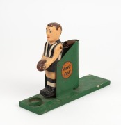 A vintage VFL goal-kicking toy, with the player in Collingwood stripes; timber, metal and plastic with a sticker to each side "KICK GOALS" and "HAVE FUN".&nbsp; 22.5cm long, 8cm tall. - 2