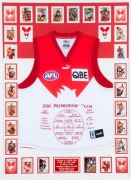 A Sydney Swans 2005 Premiership souvenir display comprising of a Swans jersey with the names and positions of the Premiership Team embroidered on the front surrounded by 21 signed cards and other unsigned cards, together with a plaque describing the four 
