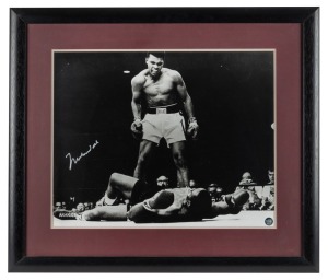 MUHAMMAD ALI: Signed black and white photograph of Ali standing over Sonny Liston, window mounted, framed and glazed with CofA verso, overall 61 x 71cm.