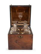An antique English mahogany four bottle spirit tantalus&nbsp;with original gilt decorated decanters and glass, circa 1830, 23cm high, 18cm wide, 18cm deep