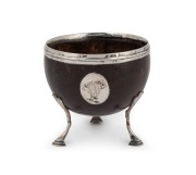 An antique sterling silver mounted coconut cup resting on pad feet, circa 1800, 9cm high
