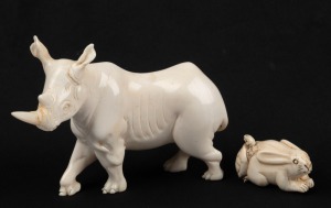 A Japanese carved ivory netsuke of a tortoise and hare; together with a carved ivory statue of a rhinoceros, signed "Musoni", (2 items), the larger 8cm high
