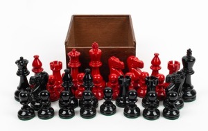 A set of black and red lacquered timber chess pieces, 20th century, the kings 10cm high, 4cm diameter bases