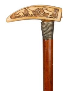 A fine antique Australian walking stick with carved whale tooth handle,&nbsp;depicting Aboriginal hunting scene with kangaroos and carved with native quoll emerging from its&nbsp;burrow. Full Malacca cane with brass ferrule and silvered collar, circa 1880, 90cm hig