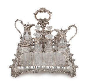 An English Georgian sterling silver nine piece cruet set with Rococo&nbsp;floral border standing on acanthus and shell feet. The cruet bottles of&nbsp;reeded crystal form with conforming acanthus silver mounts. Made by&nbsp;Joseph Angell of London, 26cm high, 27cm wide,
