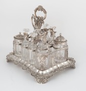 An English Georgian sterling silver nine piece cruet set with Rococo&nbsp;floral border standing on acanthus and shell feet. The cruet bottles of&nbsp;reeded crystal form with conforming acanthus silver mounts. Made by&nbsp;Joseph Angell of London, 26cm high, 27cm wide, - 2