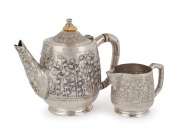 An antique Anglo-Indian silver teapot by Goopee Nath Dutt with repousse&nbsp;bamboo decoration and bamboo styled handle, signed to the base, "Goopee Nath Dutt,&nbsp;Bhowanipore, Calcutta", together with matching silver cream jug, (unsigned), circa 1890, (2 items), 